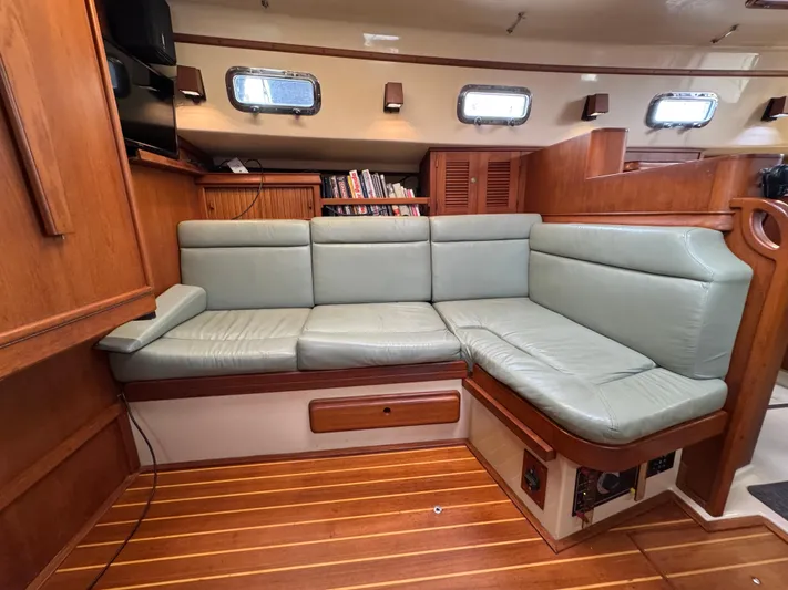 Otter II Yacht Photos Pics Interior of 1999 Island Packet 45 yacht with green leather seating and wooden flooring.