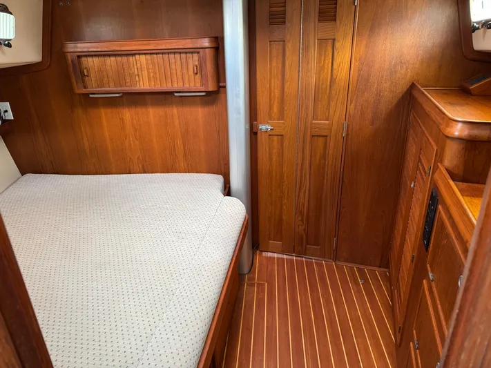 Otter II Yacht Photos Pics Cozy cabin interior of 1999 Island Packet 45 sailboat with wooden furnishings and bed.