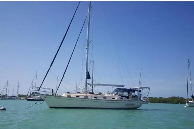 Otter II Yacht Photos Pics Island Packet 45 sailboat from 1999 anchored in calm waters under clear blue sky.