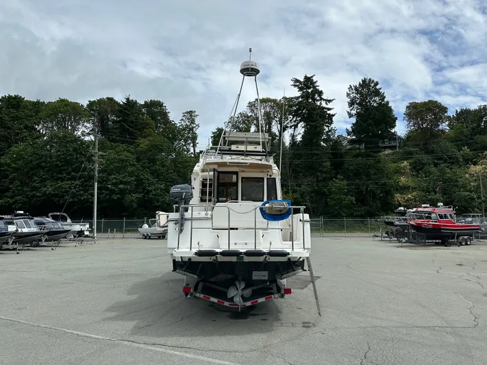  Yacht Photos Pics 2016 Cutwater CB boat on trailer in parking lot, surrounded by trees and other boats.