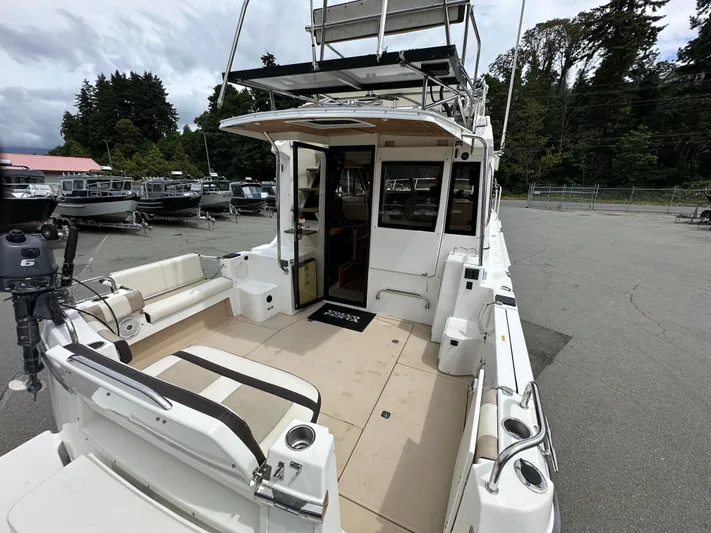  Yacht Photos Pics 2016 Cutwater CB boat with spacious deck, docked in a marina surrounded by trees.