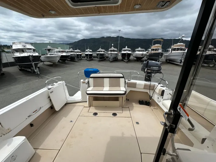  Yacht Photos Pics 2016 Cutwater CB boat interior with seating, docked among other boats under cloudy skies.
