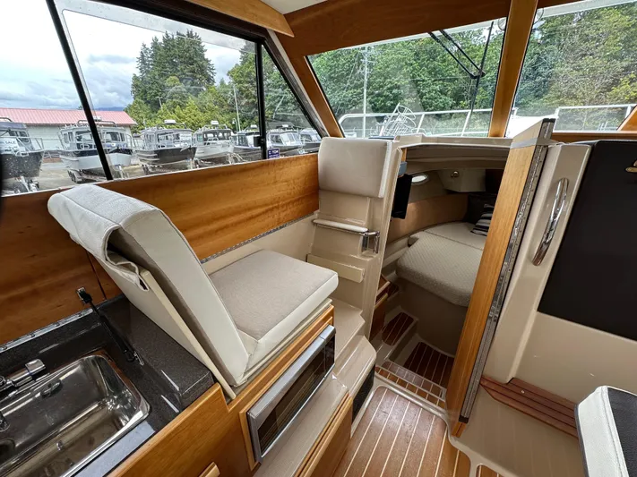  Yacht Photos Pics Interior of a 2016 Cutwater CB boat, featuring seating, sink, and cabin area.