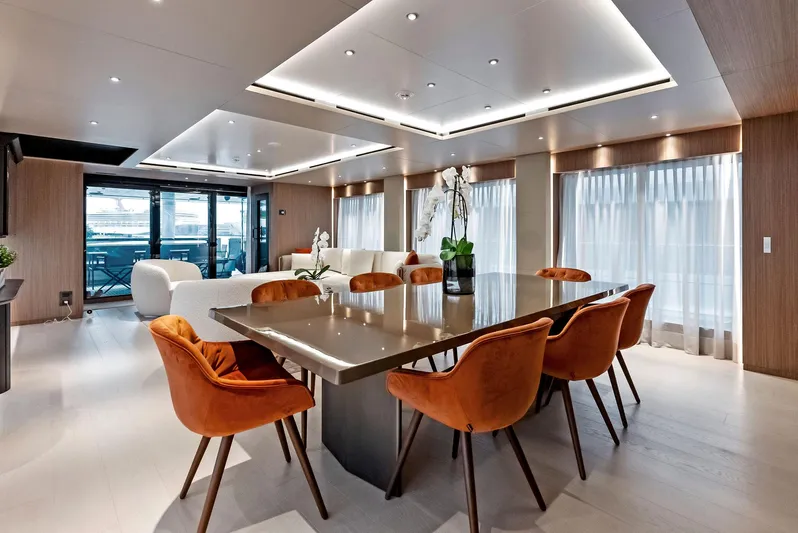 Ciao M Yacht Photos Pics Luxurious yacht interior with modern dining area, orange chairs, and elegant lighting, 2023 Custom Line 106'.