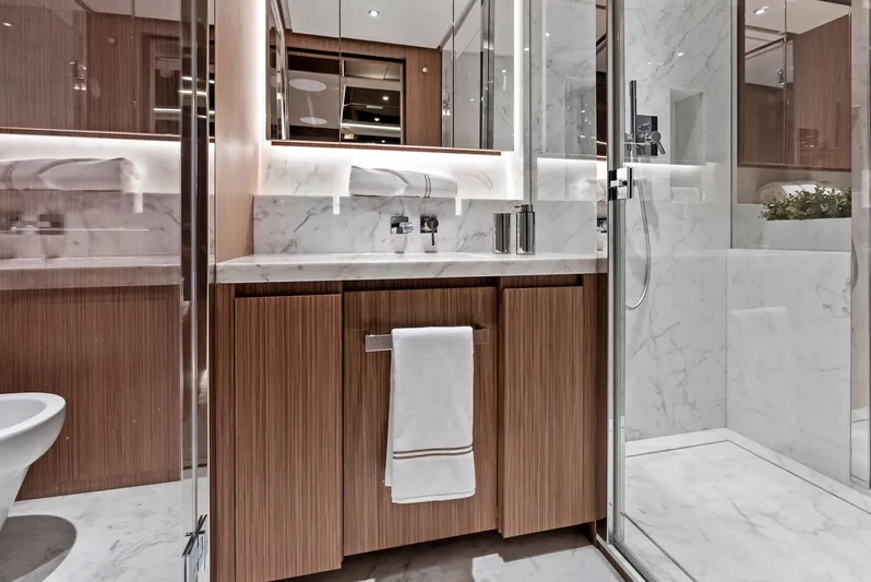 Ciao M Yacht Photos Pics Luxurious yacht bathroom with marble accents, modern fixtures, and wooden cabinetry, 2023 Custom Line 106'.