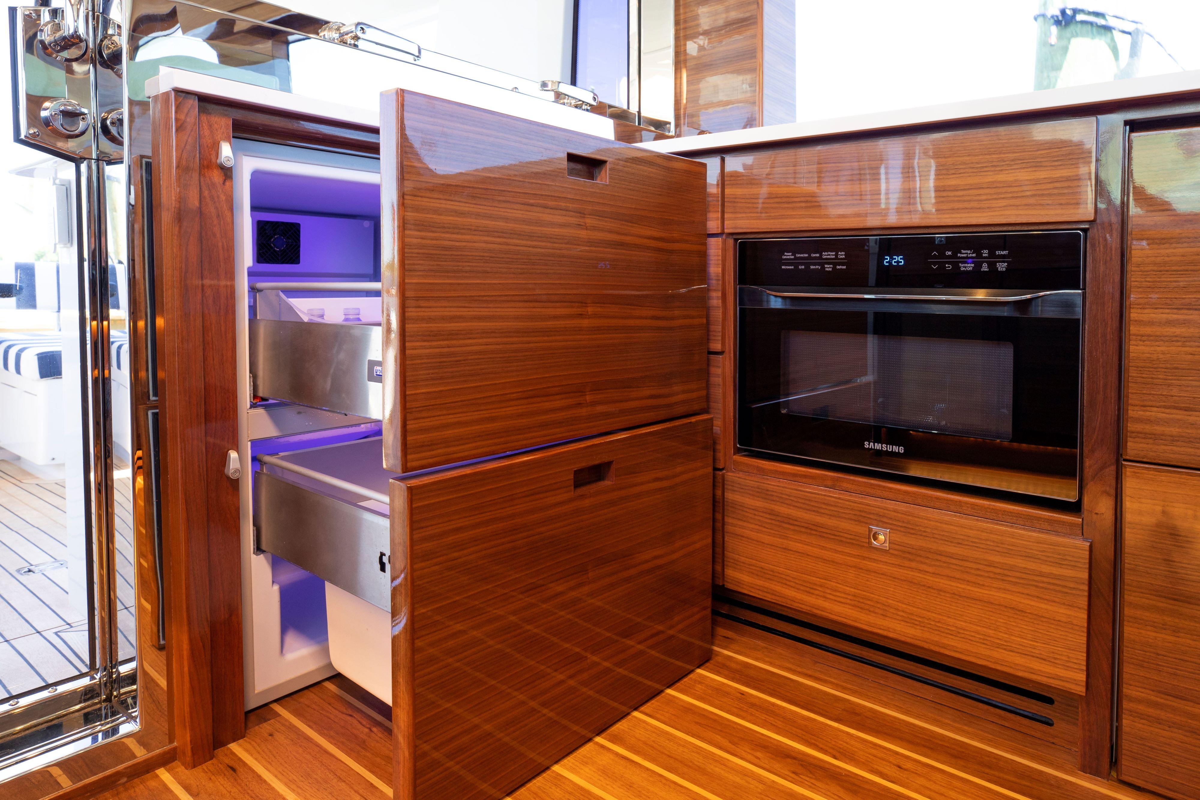 Modern kitchen area in Summit 54 yacht, featuring a built-in refrigerator and microwave.