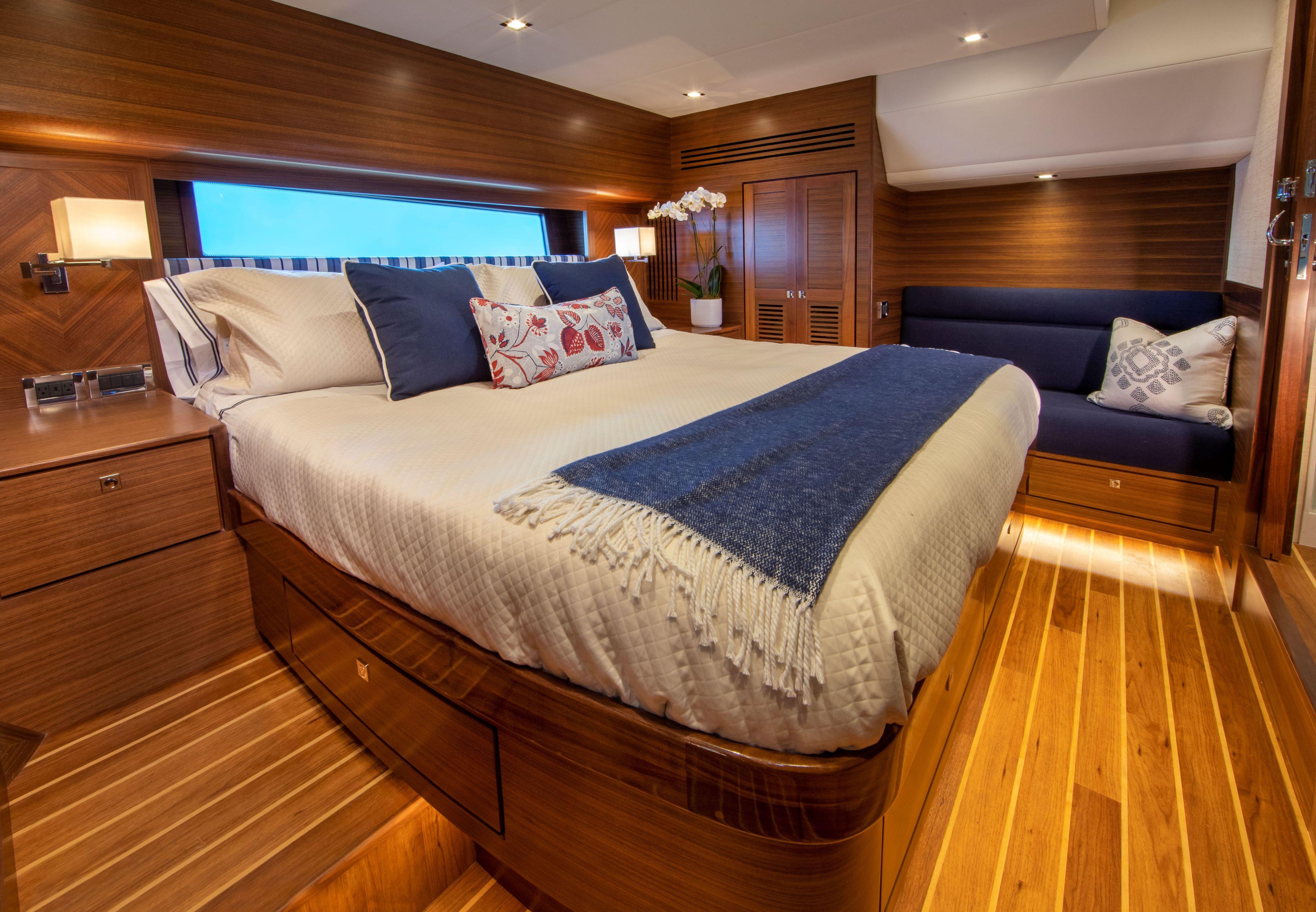Luxurious bedroom interior of Summit 54 yacht, 2025 model, with wooden finishes and cozy bedding.