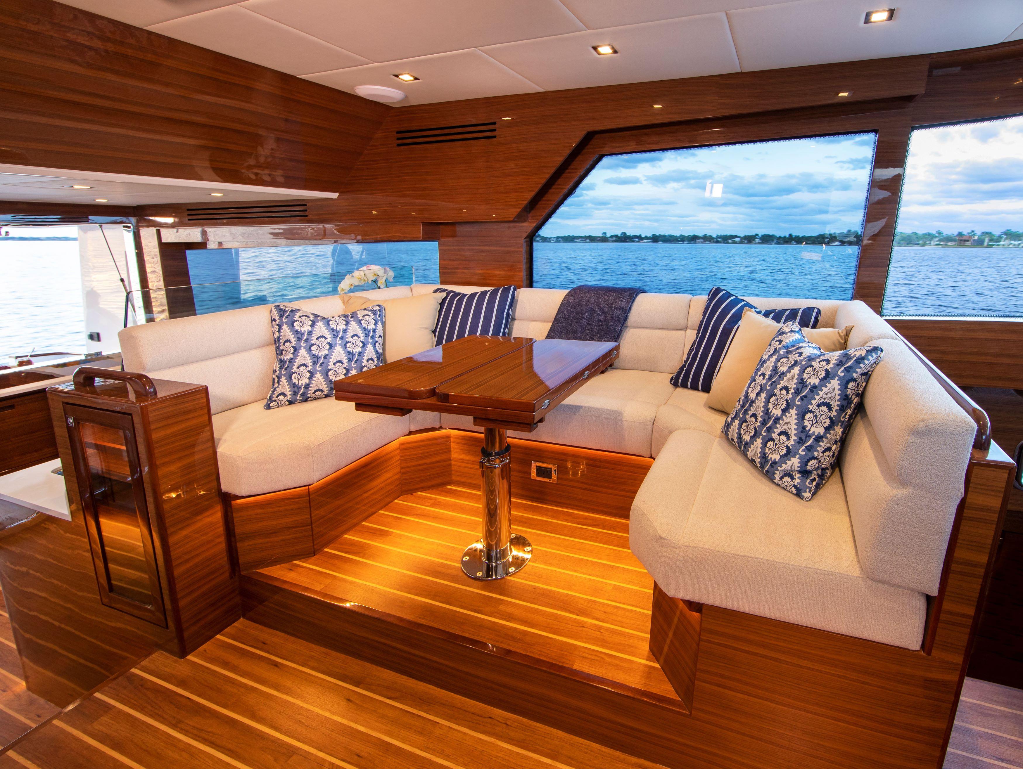 Luxurious interior of 2025 Summit 54 yacht with plush seating and scenic window view.