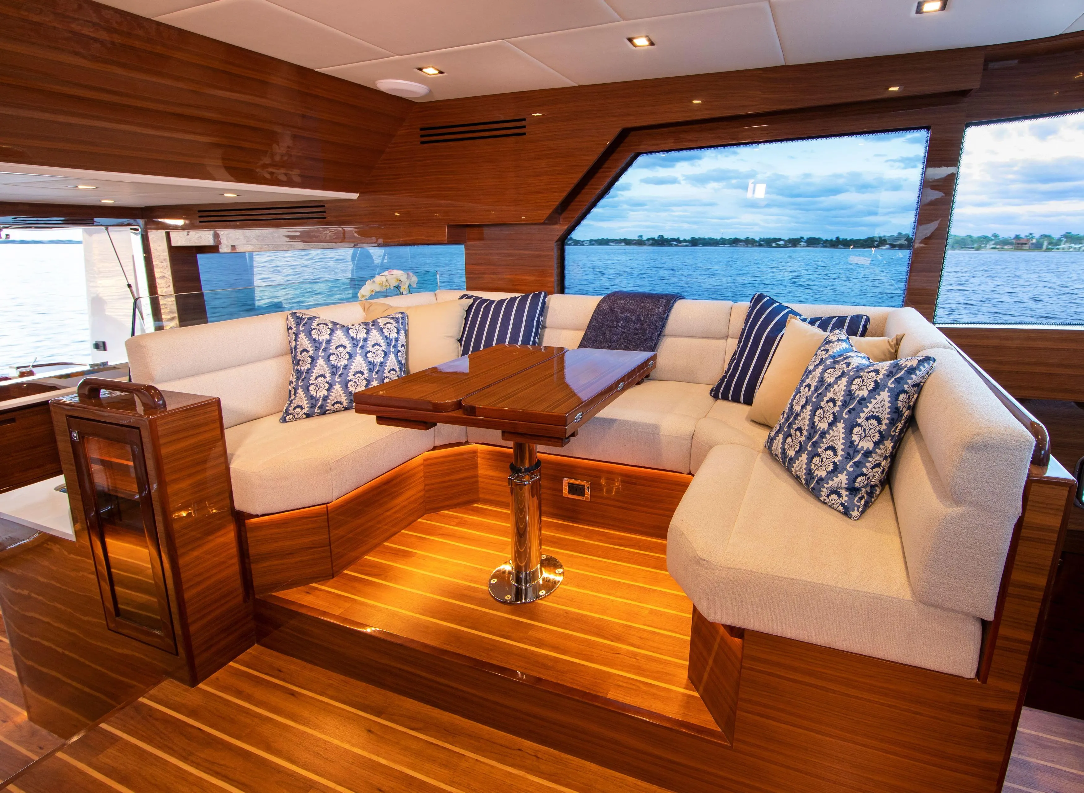 Luxurious interior of 2025 Summit 54 yacht with plush seating and scenic window view.