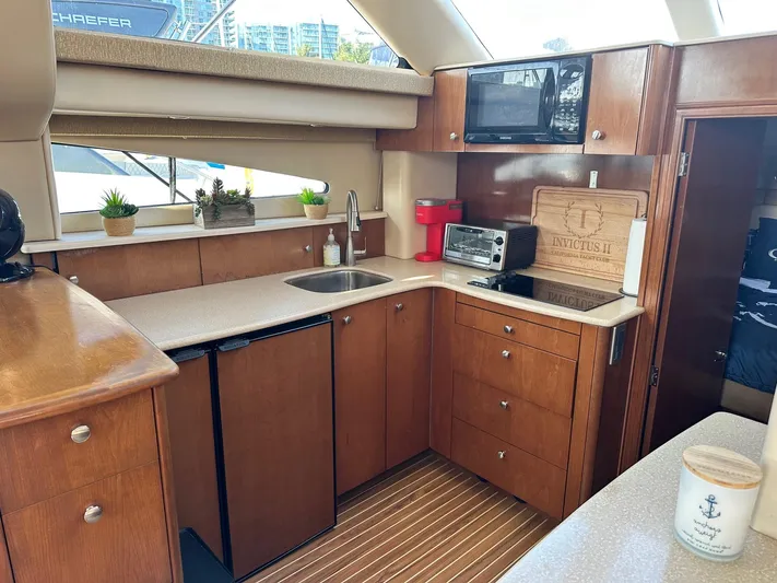 Invictus II Yacht Photos Pics Luxurious 2006 Meridian 368 yacht kitchen with modern appliances and wooden cabinetry.