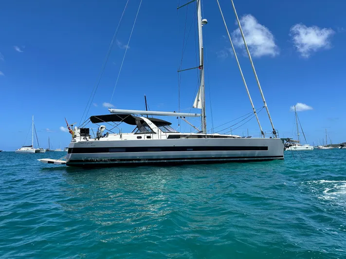  Yacht Photos Pics 2019 Beneteau Oceanis Yacht 62 sailing on clear blue waters under a sunny sky.