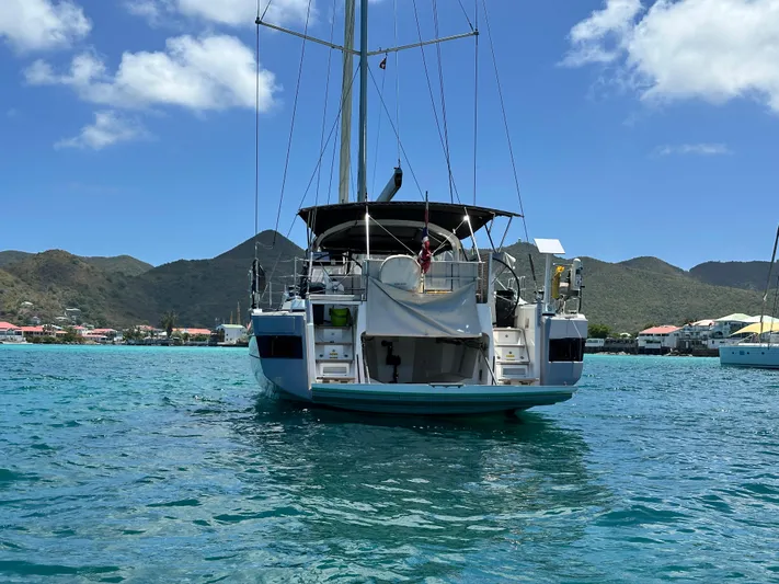  Yacht Photos Pics Beneteau Oceanis Yacht 62, 2019 model, anchored in scenic bay with mountains.