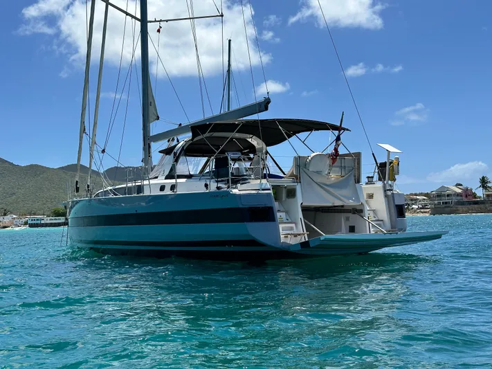  Yacht Photos Pics 2019 Beneteau Oceanis Yacht 62 sailing on turquoise waters under a clear sky.