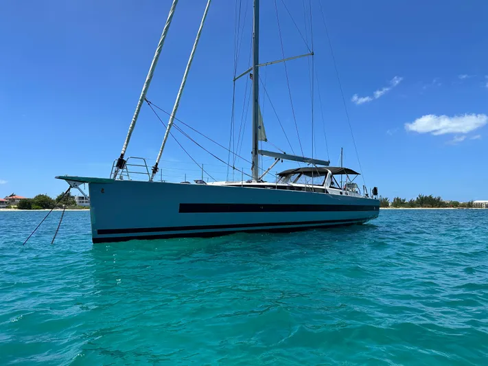  Yacht Photos Pics 2019 Beneteau Oceanis Yacht 62 sailing on clear turquoise waters under a blue sky.