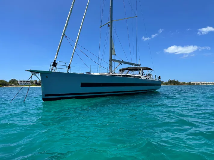  Yacht Photos Pics 2019 Beneteau Oceanis Yacht 62 sailing on clear turquoise waters under a bright blue sky.