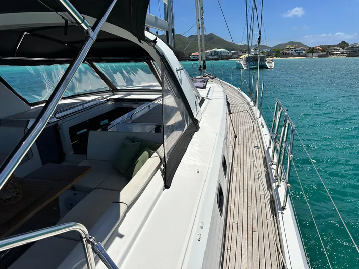  Yacht Photos Pics 2019 Beneteau Oceanis Yacht 62 sailing on turquoise waters near a scenic coastline.