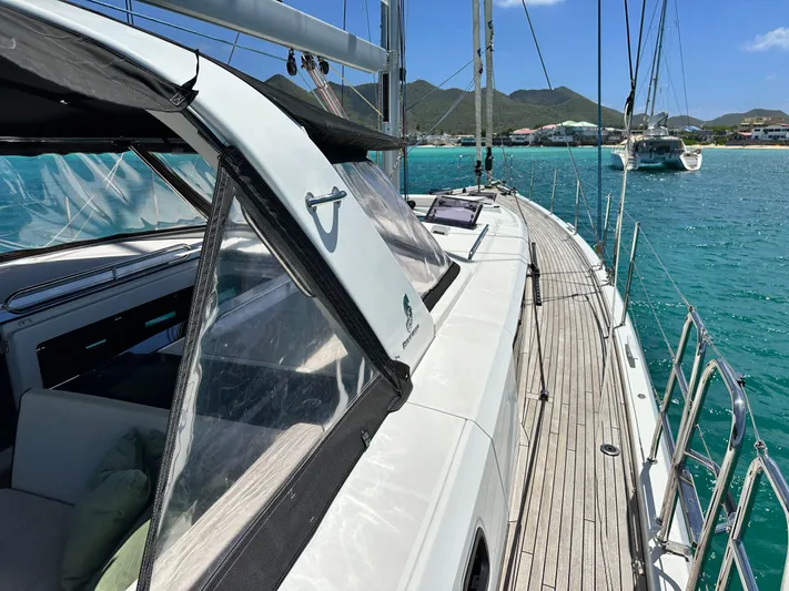  Yacht Photos Pics 2019 Beneteau Oceanis Yacht 62 sailing in turquoise waters near scenic coastline.