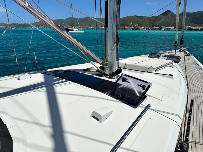  Yacht Photos Pics 2019 Beneteau Oceanis Yacht 62 on turquoise waters with scenic mountain backdrop.