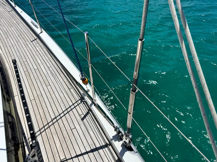  Yacht Photos Pics Deck view of 2019 Beneteau Oceanis Yacht 62 sailing on turquoise water.