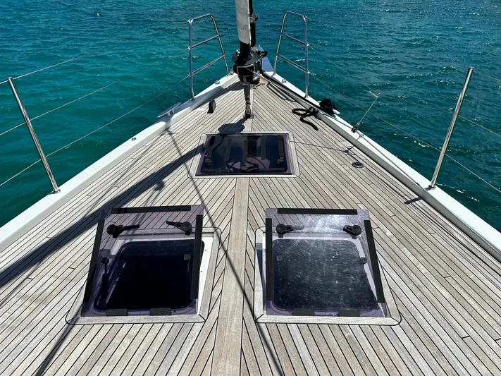  Yacht Photos Pics 2019 Beneteau Oceanis Yacht 62 deck with hatches, sailing on clear blue water.