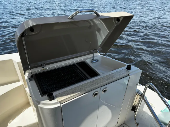 Seas The Day Yacht Photos Pics Outdoor grill on a 2017 Carver C40 yacht, open lid, near water.