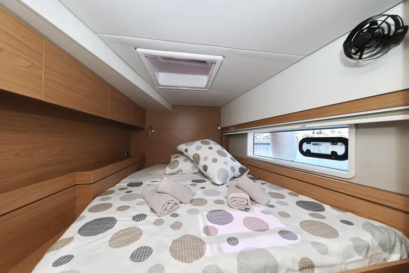 Breeze Yacht Photos Pics Cozy cabin interior of 2025 Bali 4.4 yacht with polka dot bedding and window view.