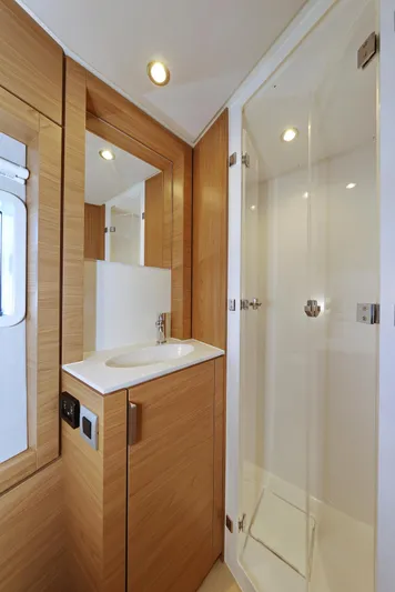 Breeze Yacht Photos Pics Modern yacht bathroom with wood accents, glass shower, and sleek sink. Bali 4.4, 2025 model.