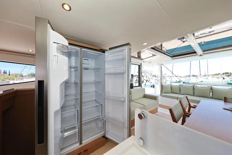 Breeze Yacht Photos Pics Luxurious Bali 4.4 yacht interior with open fridge, spacious seating, and marina view.