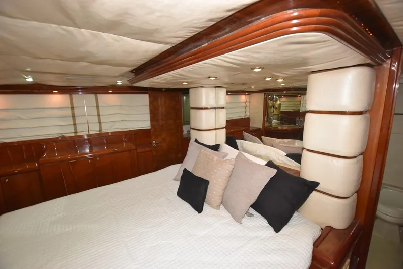 Big Hatt Yacht Photos Pics Luxurious bedroom interior of 1998 Hatteras 74 Sport Deck yacht with elegant wood finish.