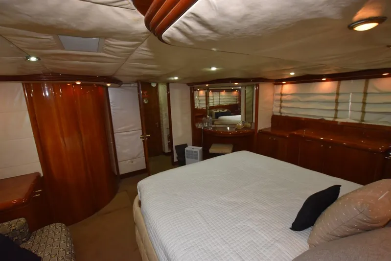 Big Hatt Yacht Photos Pics Luxurious bedroom interior of 1998 Hatteras 74 Sport Deck yacht with elegant wood finishes.