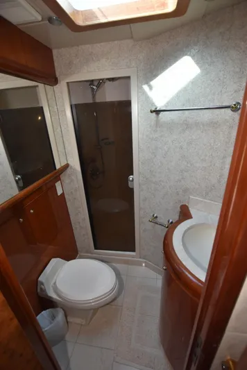 Big Hatt Yacht Photos Pics Bathroom interior of 1998 Hatteras 74 Sport Deck yacht, featuring shower and toilet.