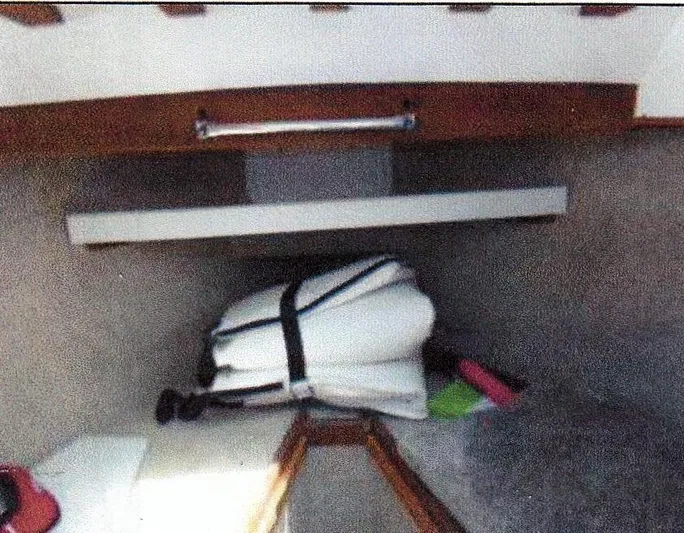 Janet Lynn Yacht Photos Pics Interior of 1999 Custom 30 Novi Hardtop Cruiser with folded white cushions and wooden accents.