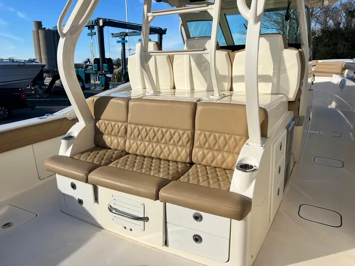  Yacht Photos Pics Luxurious seating on 2017 Scout 420 LXF boat with tan upholstery and storage drawers.
