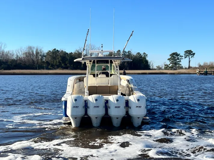  Yacht Photos Pics 2017 Scout 420 LXF boat with four outboard engines on a calm river.