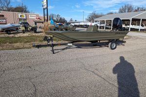 2026 Tracker Grizzly 1648 SC boat on trailer at dealership, sunny day.