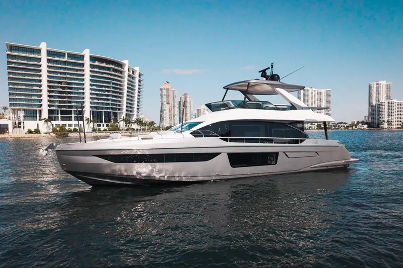 Spysea Yacht Photos Pics 2023 Azimut Fly 68 yacht cruising near modern waterfront buildings.