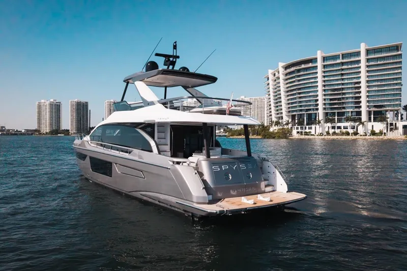 Spysea Yacht Photos Pics 2023 Azimut Fly 68 yacht on water with modern buildings in background.