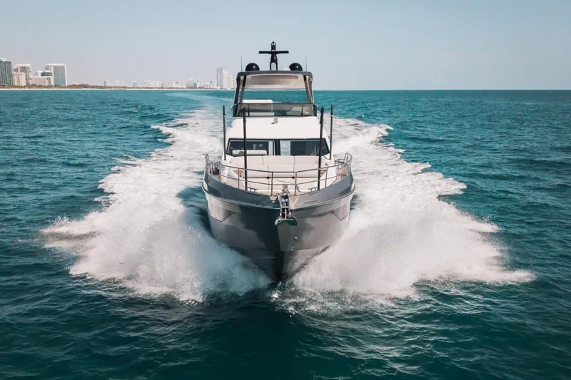 Spysea Yacht Photos Pics 2023 Azimut Fly 68 yacht cruising on open sea with city skyline in background.