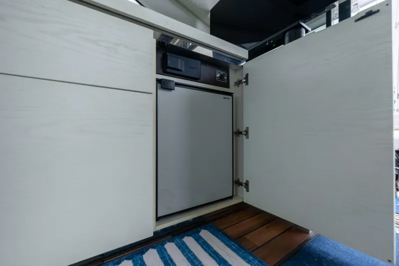 Treasure X Yacht Photos Pics 2015 Azimut 55S yacht interior with open cabinet revealing compact refrigerator.