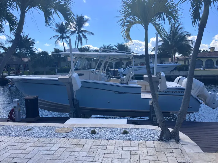  Yacht Photos Pics 2018 Grady-White Canyon 336 boat docked by palm trees, sunny waterfront setting.