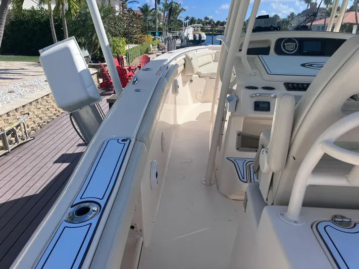  Yacht Photos Pics 2018 Grady-White Canyon 336 boat interior with helm and seating, docked by a waterfront.
