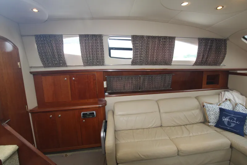 Gemini Yacht Photos Pics Interior of 2004 Cruisers Yachts 405 Express Motoryacht with beige sofa and wooden cabinetry.