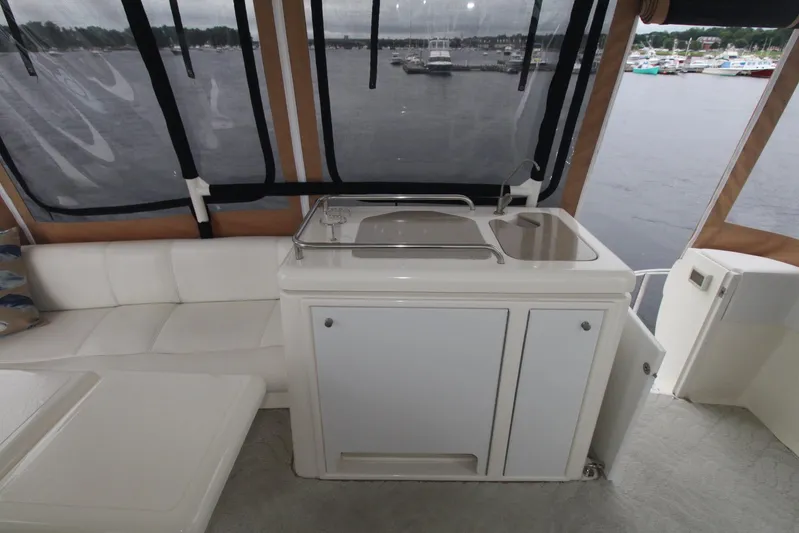 Gemini Yacht Photos Pics 2004 Cruisers Yachts 405 Express Motoryacht interior with sink and seating, overlooking marina.