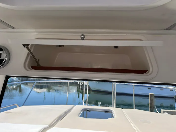  Yacht Photos Pics 2024 Tuna catamaran interior storage compartment with open hatch, docked at marina.