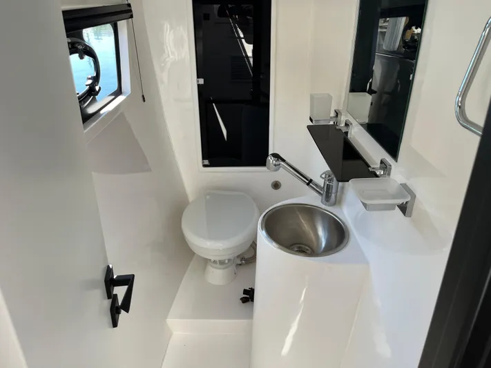  Yacht Photos Pics Modern bathroom in 2024 Tuna catamaran with toilet, sink, and window.