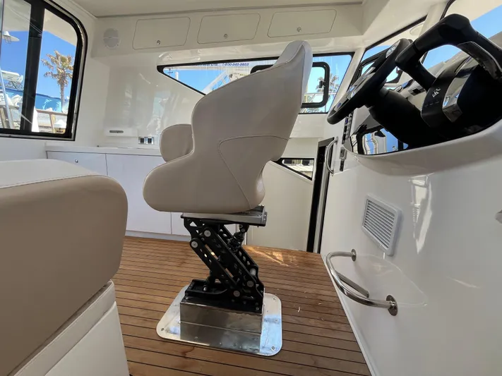  Yacht Photos Pics 2024 Tuna catamaran interior with modern helm seat and wooden flooring.
