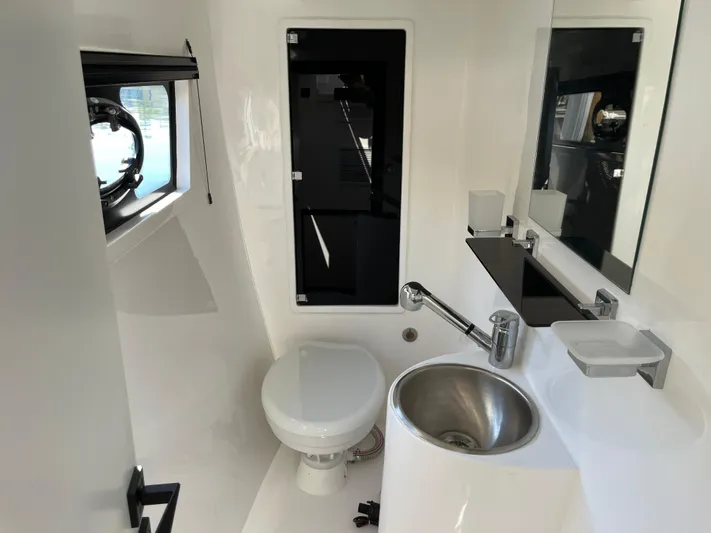  Yacht Photos Pics Modern bathroom in 2024 Tuna catamaran, featuring sleek fixtures and compact design.