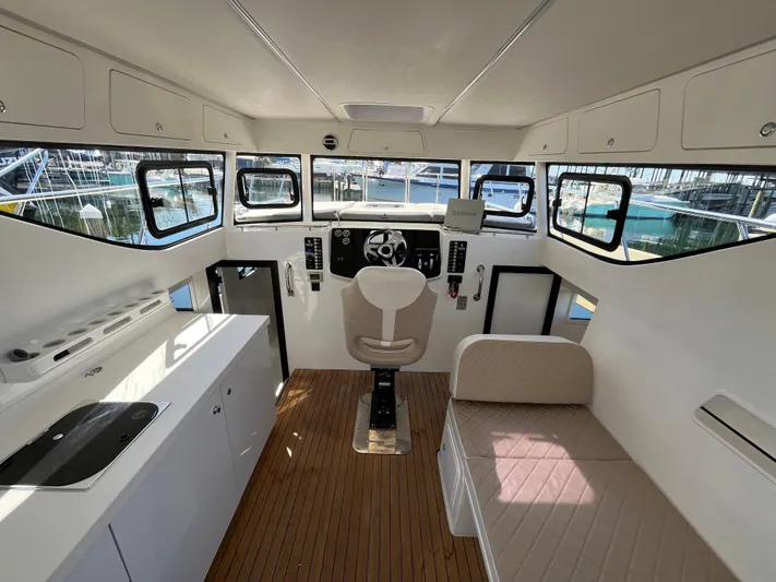  Yacht Photos Pics 2024 Tuna catamaran interior with modern helm, seating, and kitchenette.