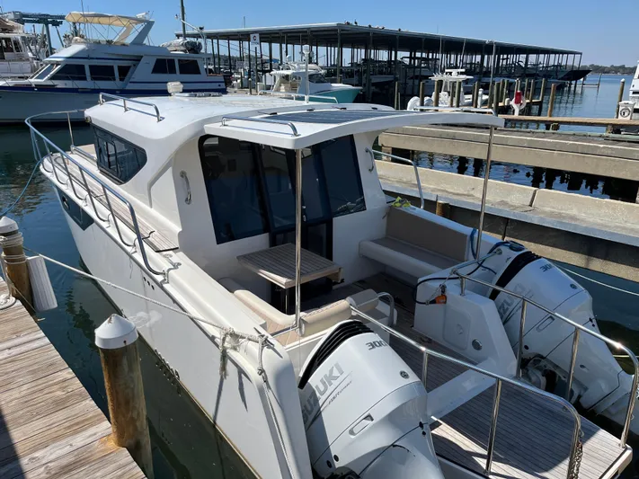  Yacht Photos Pics 2024 Tuna catamaran docked, featuring dual outboard engines and spacious deck area.