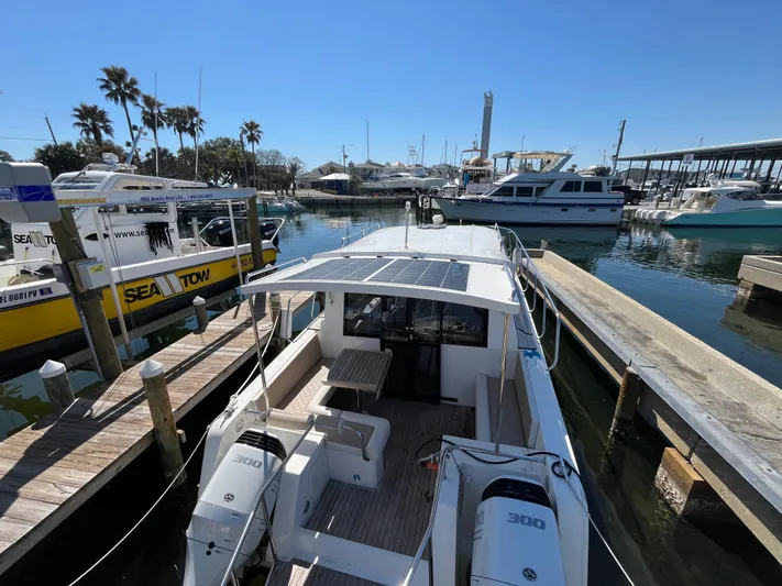  Yacht Photos Pics 2024 Tuna catamaran docked at marina with twin engines and solar panels.